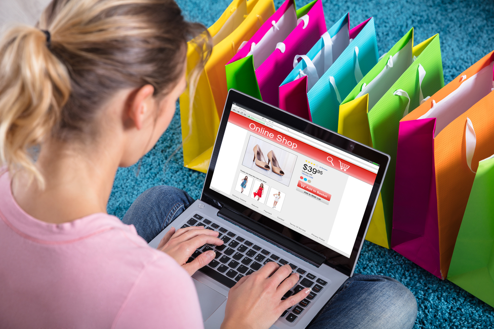 online business - Close-up Of Woman Shopping Online Using Laptop With Colorful Shopping Bags On Carpet - borzo